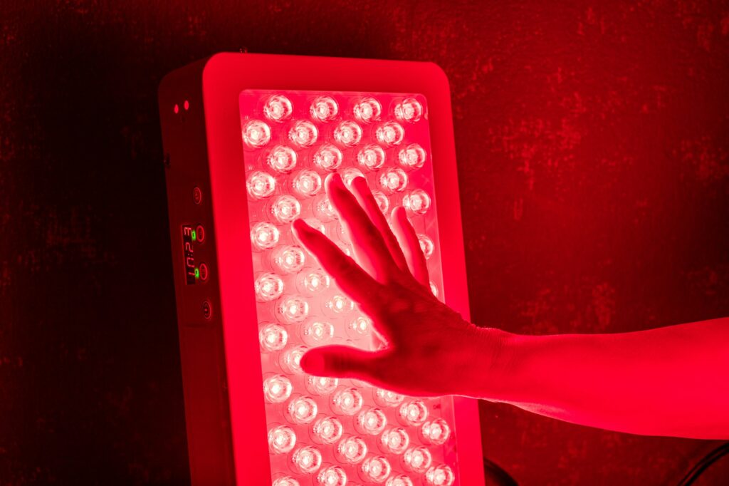 Closeup of hand touching Red Light Therapy Panel LEDs